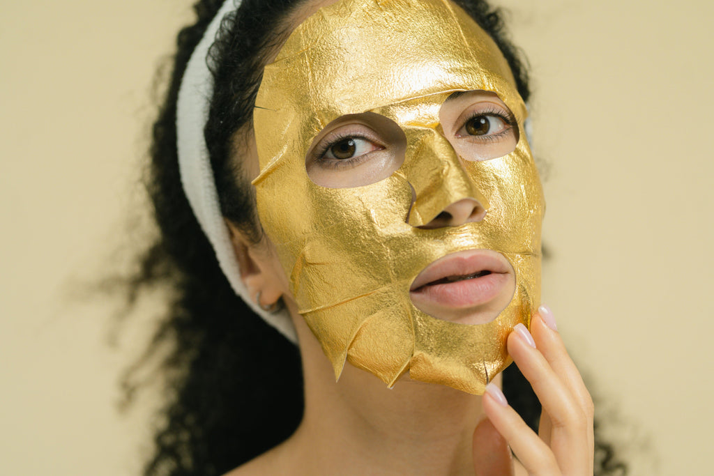 Masque tissu doré appliqué sur le visage — rituel beauté LUMÆE